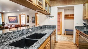 A kitchen with granite countertops, wooden cabinets, and a built-in oven. - Mountain Modern Beaver Creek Village Condo, Ski-In and Out, w/ Hot Tub and Views (Beaver Creek)