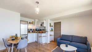 A compact living space with a dining area, kitchenette, and a sofa. - Le Flamingo - Première conciergerie (Palavas-les-Flots)