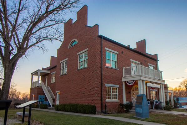 A brick building with a balcony, a staircase, and a sign reading "Zions Mercantile". - Nauvoo Temple House Hotel (Nauvoo)