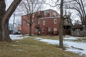 A red brick building with multiple windows and a wooden deck. - Nauvoo Temple House Hotel (Nauvoo)