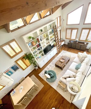 Relax in this open living area with a sofa, dining table, and entertainment unit.