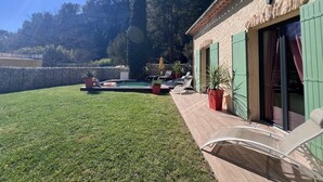 A sunny outdoor area with a swimming pool, lounge chairs, and a stone wall. - Maison idéale pour les familles avec piscine privée - Fontaine-de-Vaucluse (Fontaine-de-Vaucluse)
