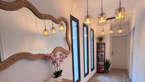 A hallway with a wooden desk, a mirror, pendant lights, and a plant. - Maison idéale pour les familles avec piscine privée - Fontaine-de-Vaucluse (Fontaine-de-Vaucluse)