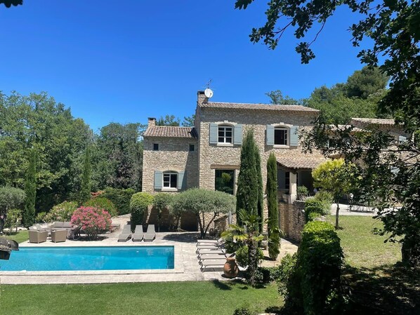 A stone house with a swimming pool, surrounded by greenery and trees. - Propriété d'exception au coeur du Luberon (Robion)