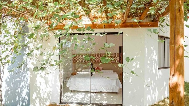 A bedroom with a bed, a window, and a view of the outdoors. - Pousada Caju do Mato (Prado)