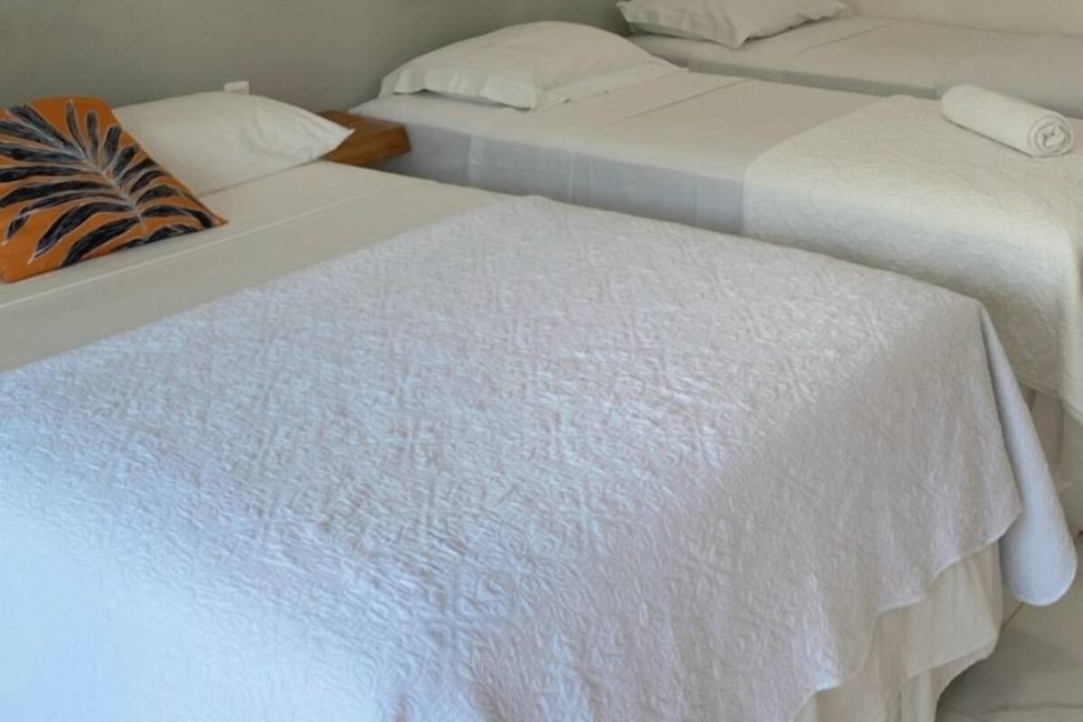 A hotel room with two beds, a grey headboard, and a white wall with decorative circular wall art.