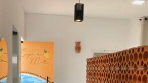 A bathroom with two large, round, terracotta sinks, a wooden decorative wall, and a mural of a beach scene on the wall. - Pousada Caju do Mato (Prado)