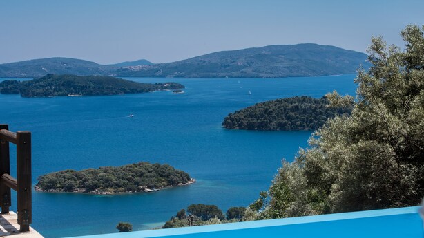 A view of a pool overlooking a large body of water with several islands, surrounded by trees and hills. - Villa Pasithea - breathtaking seaviews, infinity pool, privacy, close to beach (Perigiali)