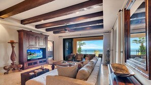 A spacious living room with a large television, comfortable seating, and a view of the ocean. - Special Rates All Sumer Long, Corner 2 Bd Condo at Hacienda Beach Club!! (Cabo San Lucas)
