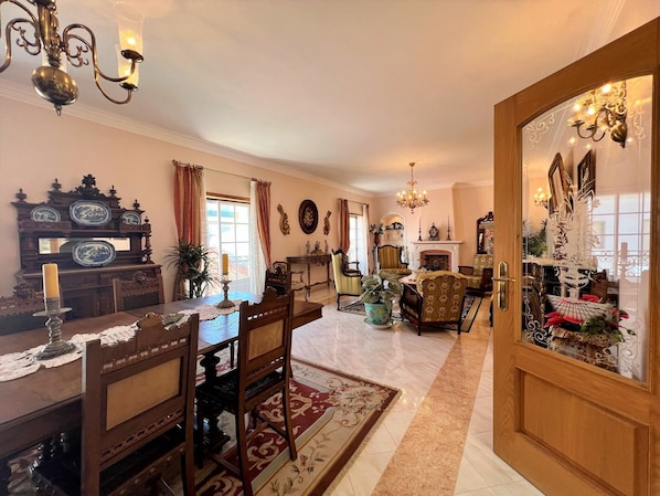 A traditional living room with a fireplace, wooden furniture, and decorative items.
