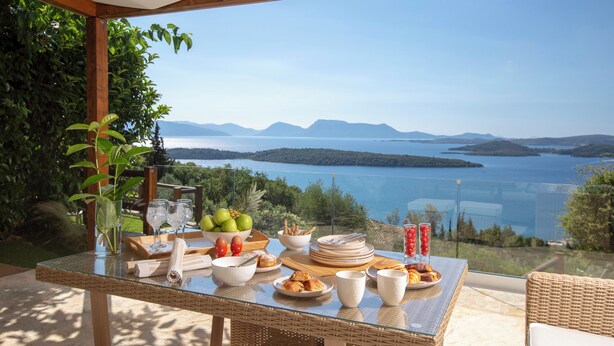 Een ontbijt tafel met een prachtig uitzicht op een meer en bergen.