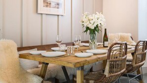 A dining table set with plates, glasses, and a vase of flowers. - Albany (Port Isaac)