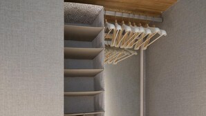 Un armadio a muro con ante a specchio, ripiani in legno e spazio per appendere i vestiti.