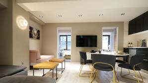 Un salon moderne comprenant un canapé, une table basse et un coin repas avec des chaises et une table.