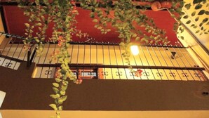 A hotel with a red exterior, a balcony with metal railings, and a sign with numbers indicating room numbers. - Buongiorno Suites Sullana I (Sullana)