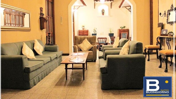 A living room with sofas, a coffee table, and a dining area with a table and chairs. - Buongiorno Suites Sullana I (Sullana)