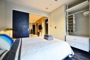 A hotel room with a bed, a wardrobe, and a bathroom visible through an open door. - Real Life Meguro River Fancy 1BR 4pax Shibuya (Tokyo)