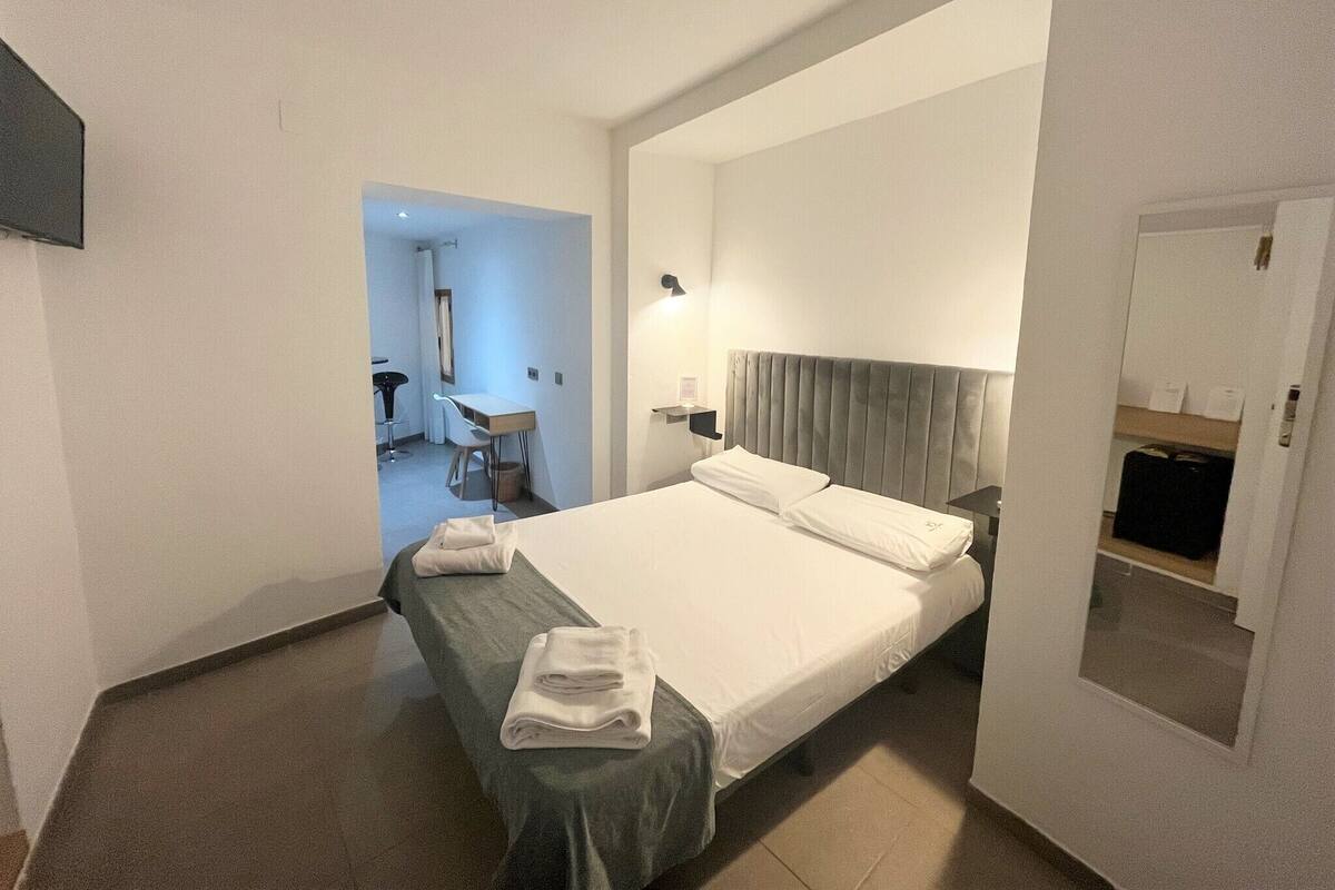 Een hotelkamer met een groot bed, een bureau en een stoel.