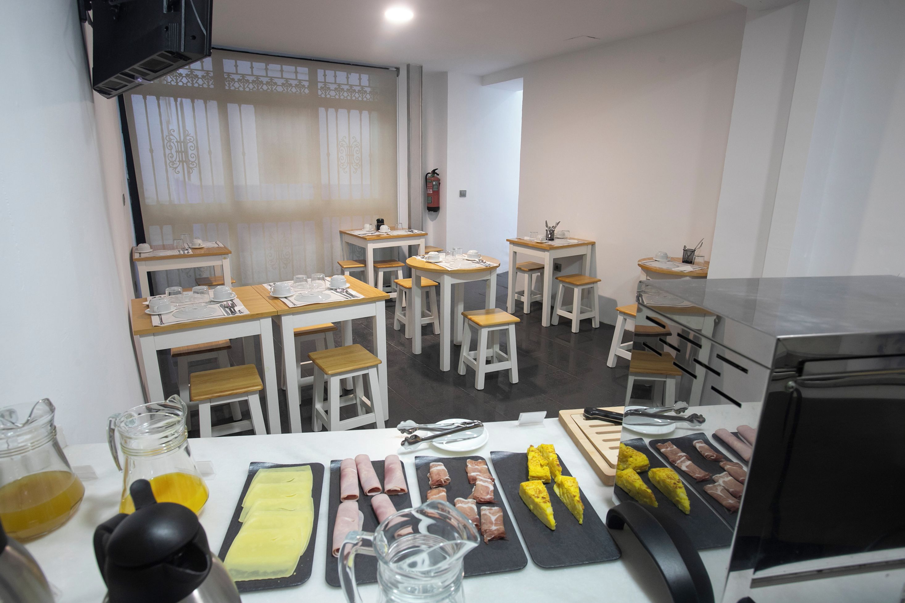 A dining area with multiple tables, chairs, and a variety of food items displayed on platters.