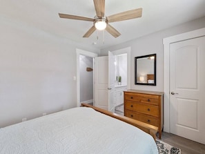 Cozy retreat with a large bed, dresser, and mirror, perfect for a relaxing stay.