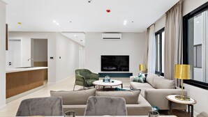 A modern living room with a sofa, a dining table set, a TV, and a window with curtains. - Mabaat - Al Malqa - 384 (Riyadh)