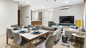 A modern living room with a dining area, a sofa set, a TV, and an air conditioning unit. - Mabaat - Al Malqa - 384 (Riyadh)