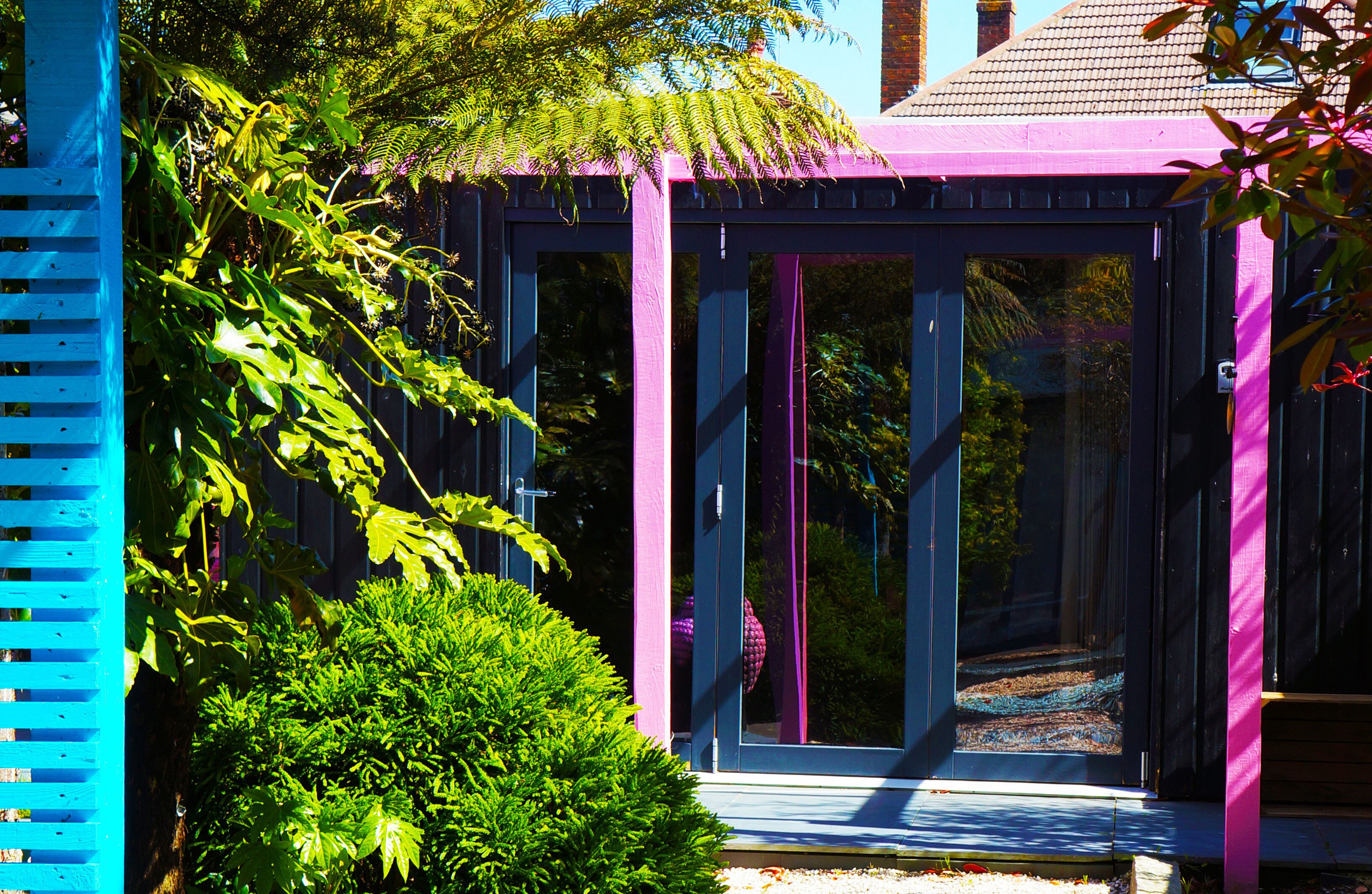 A conservatory with a glass door and a blue and purple exterior.