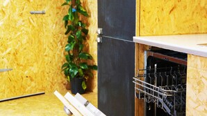A kitchen with a wooden backsplash, a potted plant, and a dishwasher. - Zen Garden Cottage - Sleeps 2 - Patio & Parking (Poole)