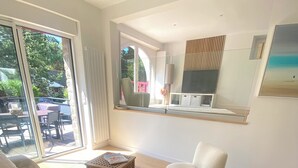 A modern bedroom with a bed, a chair, a small table, and a large window. - 4 bedroom villa in la baule-escoublac (La Baule-Escoublac)