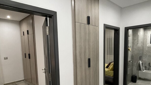 Un intérieur moderne avec un couloir menant à une chambre et à une salle de bain.