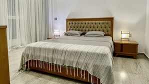 Une chambre à coucher moderne avec un grand lit, une tête de lit en bois, une table de chevet avec une lampe et un climatiseur au plafond.