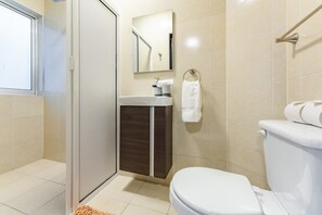 Ein modernes Badezimmer mit Toilette, Waschbecken und Spiegel.