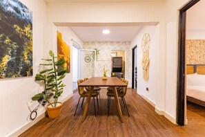 Ein stilvoller Essbereich mit Holztisch und -stühlen, einem Blumentopf und Bildern an den Wänden.
