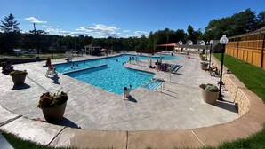 Ein Poolbereich mit mehreren Pools, Liegestühlen und Topfpflanzen.