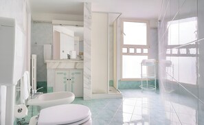 Een douche, een haardroger, een bidet, handdoeken