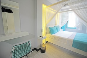 A bedroom with a bed, a bedside table, a nightstand, a wardrobe, and a window with curtains. - Seher Hanim Konagi (Bozcaada)