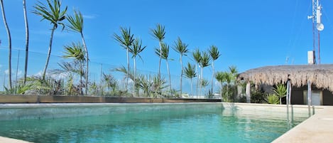 Alberca al aire libre y camastros