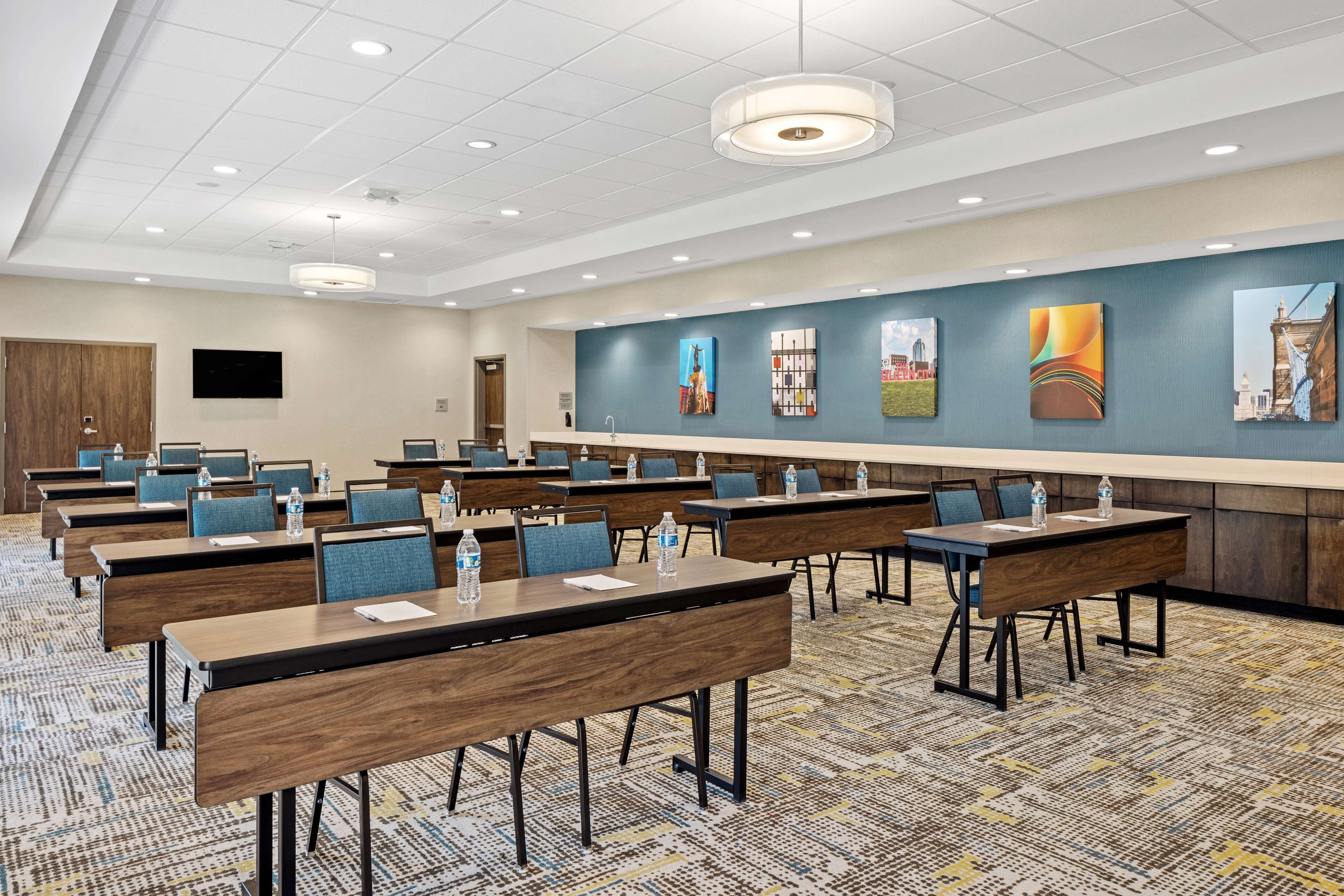 A conference room with multiple tables, chairs, and a carpeted floor.