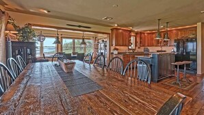 Una cocina amplia con armarios de madera, una isla grande y un comedor con una mesa larga y sillas.