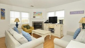 Ein Wohnzimmer mit Kamin, Fernseher und Sitzecke.