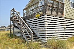 A wooden structure with a 'RENT' sign, a staircase, and a fenced area.