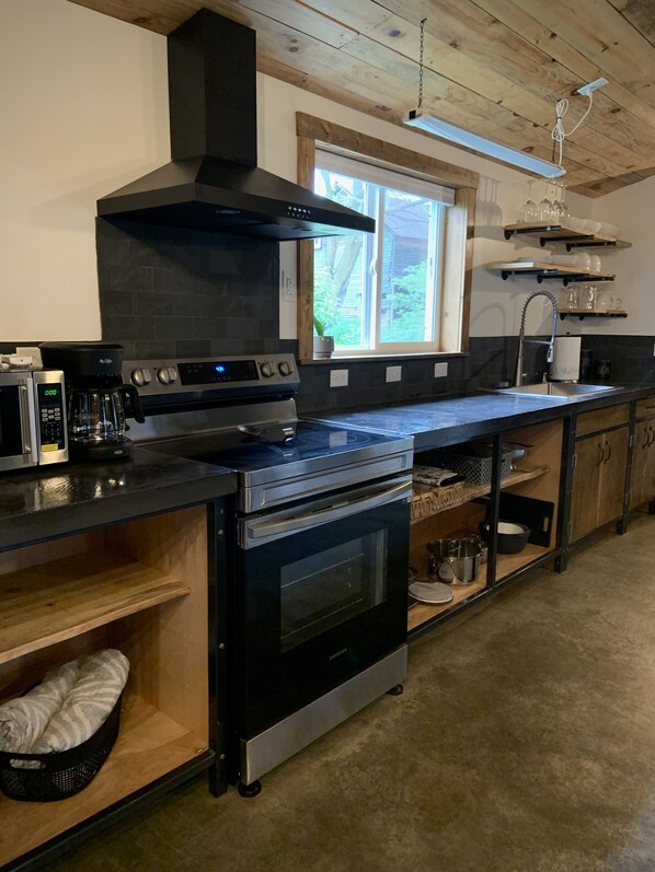 A modern kitchen with a built-in oven, microwave, and coffee maker.