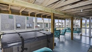 A pool area with a hot tub, seating, and large windows. - 6 bedroom, classic old nags head style oceanfront with a hot tub! (Nags Head)