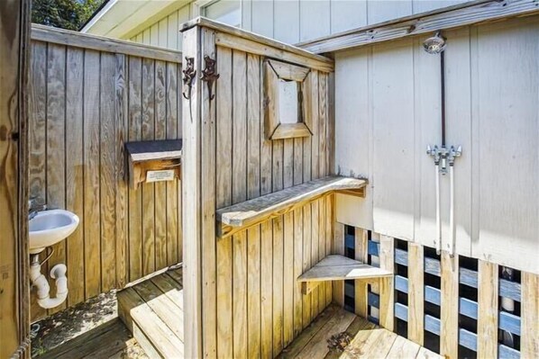 A wooden outdoor bathroom with a sink, a shower, and a small bench. - Private pool and steps to the beach in quiet Southern Shores! Perfect beach home (Southern Shores)