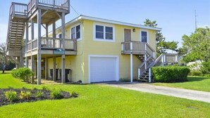 Une maison à deux étages avec un garage à l’avant, un balcon au premier étage et un escalier menant au deuxième étage.