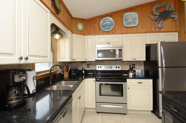 Enjoy cooking in this well-equipped kitchen with a refrigerator, double oven, microwave, sink, and coffee maker.
