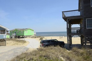 Overlooking the beach, this property features a spacious balcony and a green house with a garage.