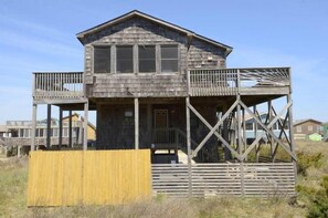 A wooden house with a balcony and a covered porch. - Semi-oceanfront with a hot tub in quiet South Nags Head! (Nags Head)