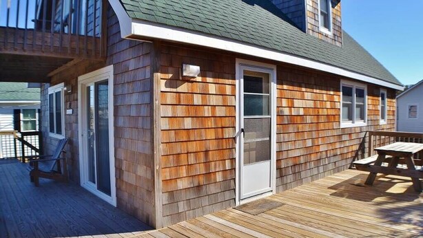 Una casa de madera con un balcón, una puerta y una ventana.