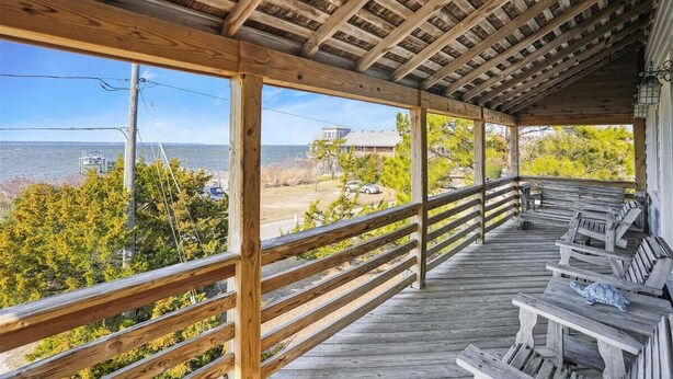Eine Holzterrasse mit Bänken mit Blick auf Strand und Meer.